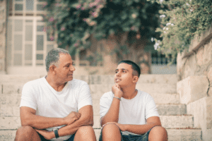 father and son have a chat sitting on stairs